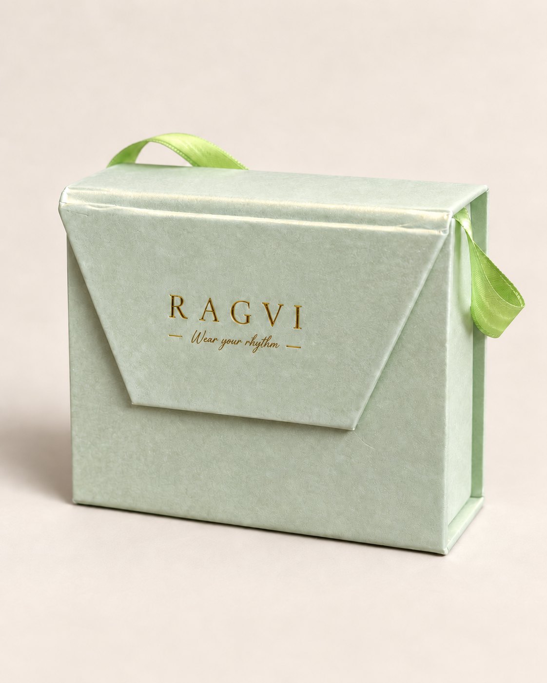 The RAGVI gift box in sage paper with a green ribbon